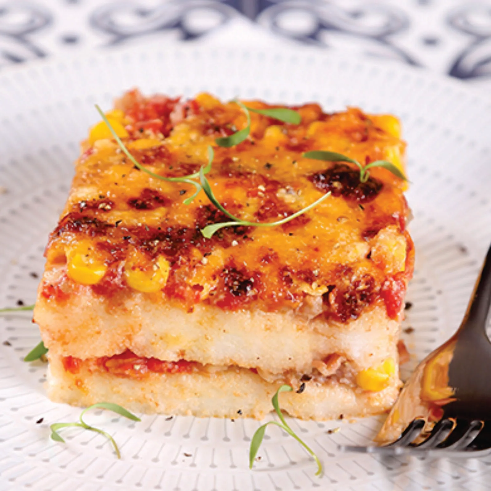 gluten-free prepared frozen , heat-n-eat ready meal that can be prepared in the microwave, airfryer or oven. Layers of ham and mushrooms cooked in a delightfully savoury onion and tomato sauce on top of maize meal porridge (pap). All topped off with a layer of cheese. (Paptert).